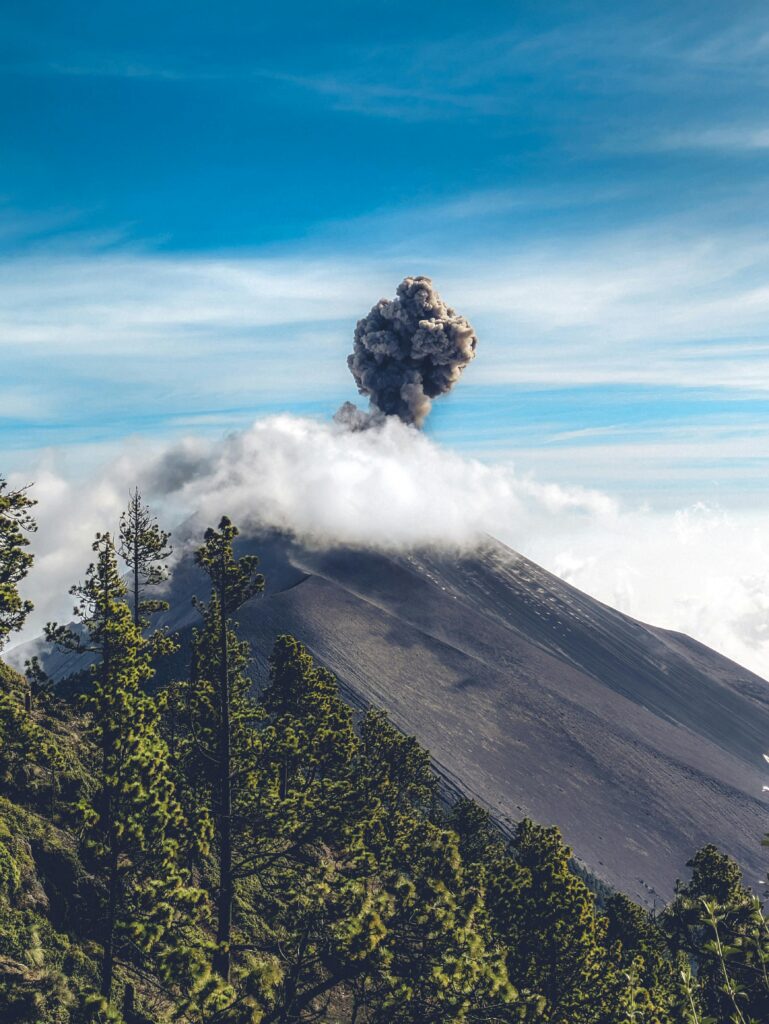A vibrant capture of volcanic activity amidst lush green surroundings in Sacatepéquez, Guatemala.